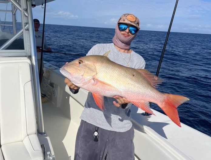 a man holding a fish on a boat