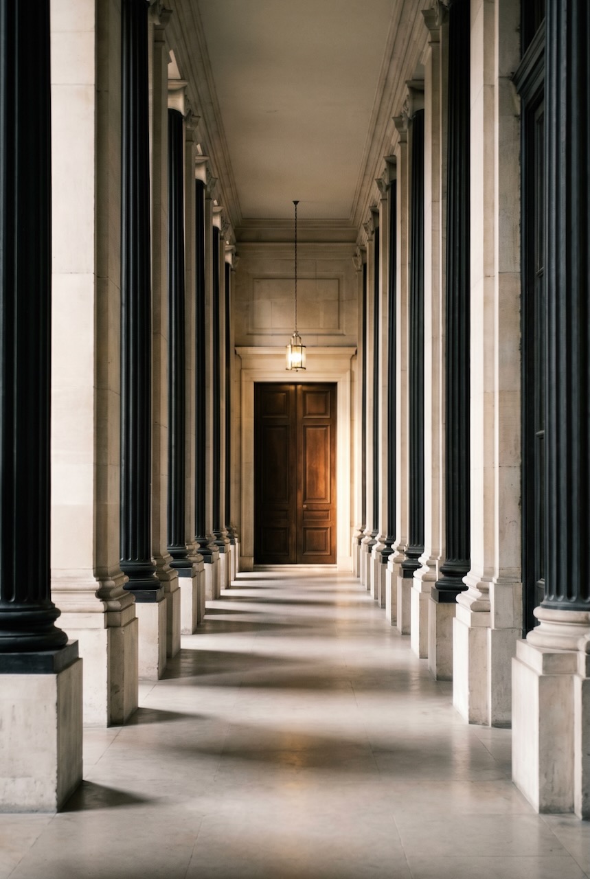 Long stone colonnade leading to a lit doorway representing KGP Event Group's strategic meeting management approach