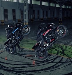 Rider cruising on the Bajaj Pulsar 220F through city streets, showcasing its aggressive and sporty street presence.