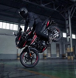 Bajaj Pulsar 220F speeding down an open highway, reflecting its high-performance capabilities and aerodynamic design.