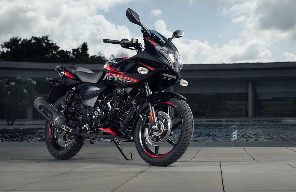 Rider maintaining a forward-leaning, sporty position on the Pulsar 220F for dynamic road performance.