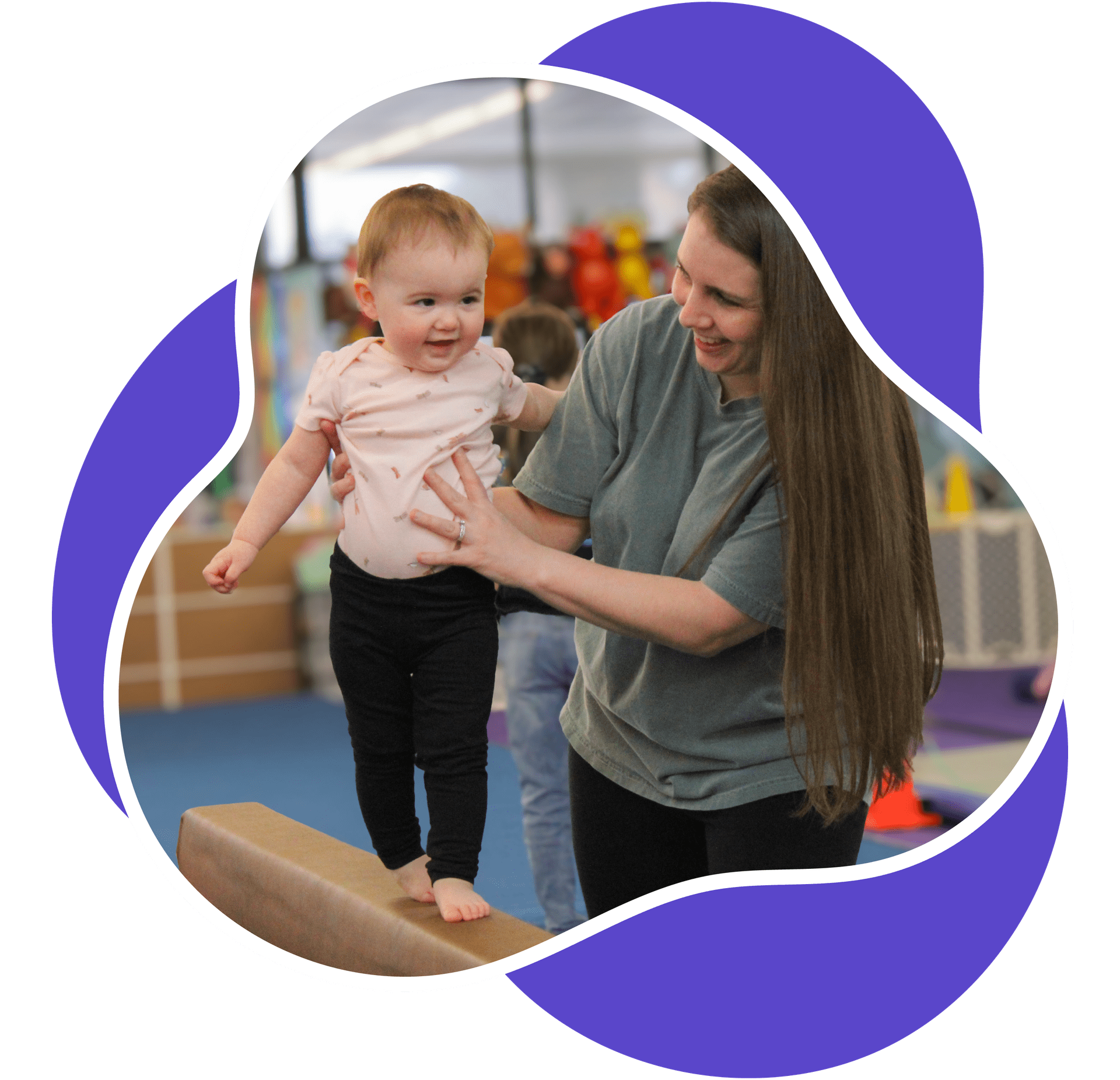 Mother helping her toddler walk on gymnastics beam.