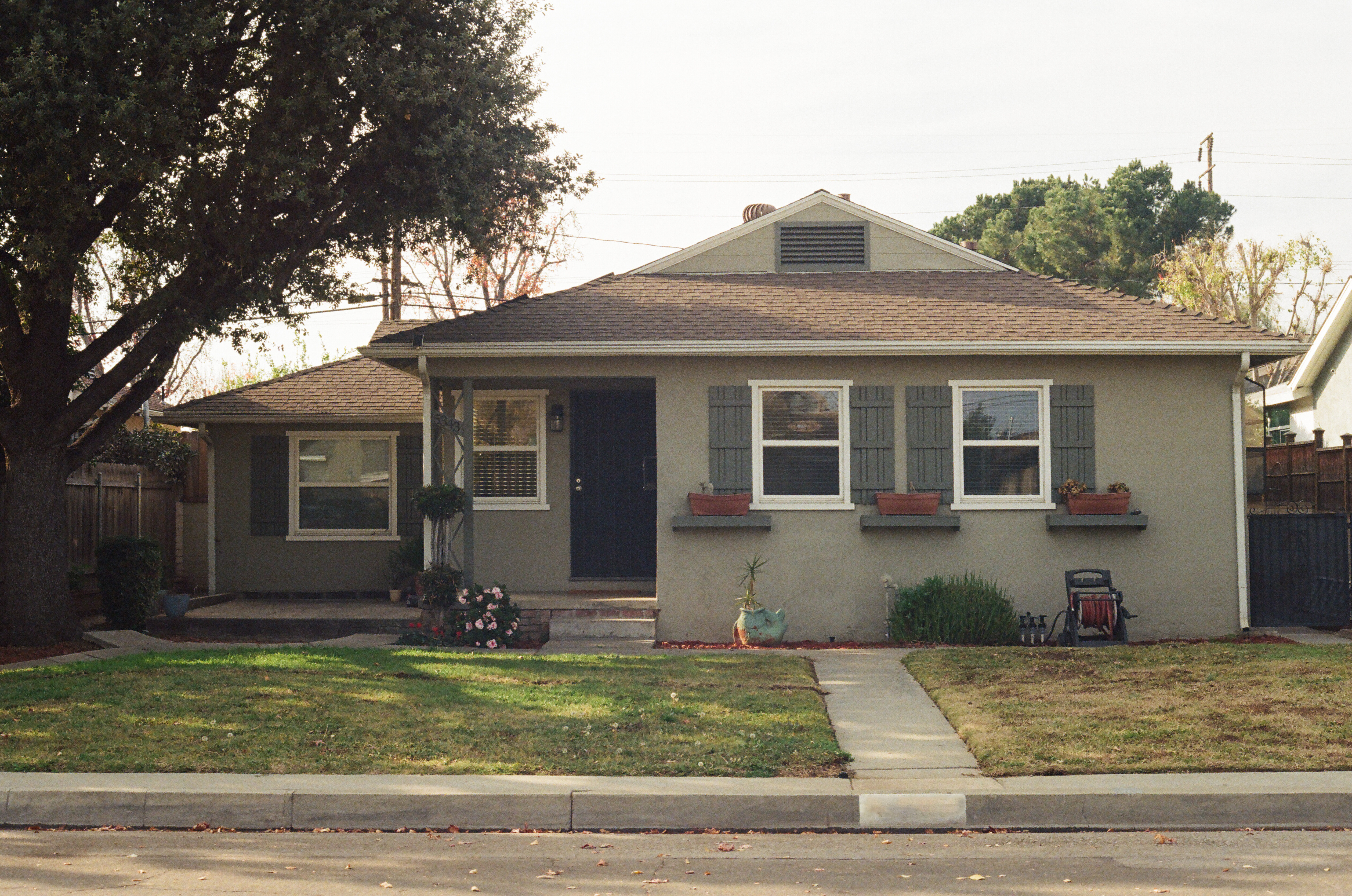 Single family home with shutter windows and a sidewalk leading up to the front door