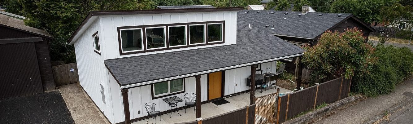 Modern accessory dwelling unit with sleek design, gray exterior, large windows, and a flat roof, built by Kimball Construction.