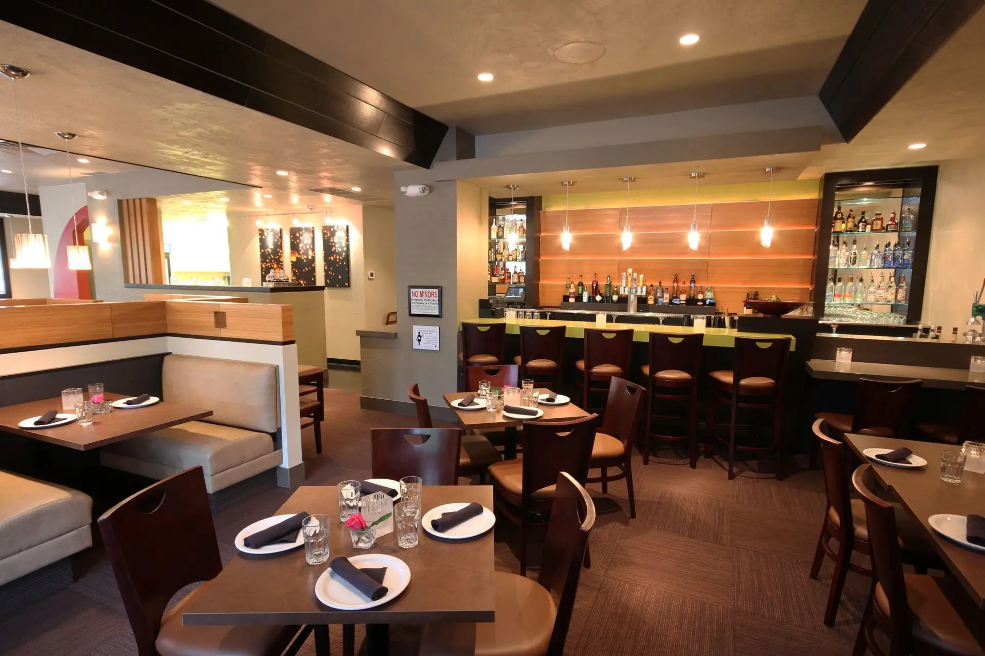 Warm, inviting interior of Ta Ra Rin Thai restaurant with wooden furniture, soft lighting, and traditional Thai decor.
