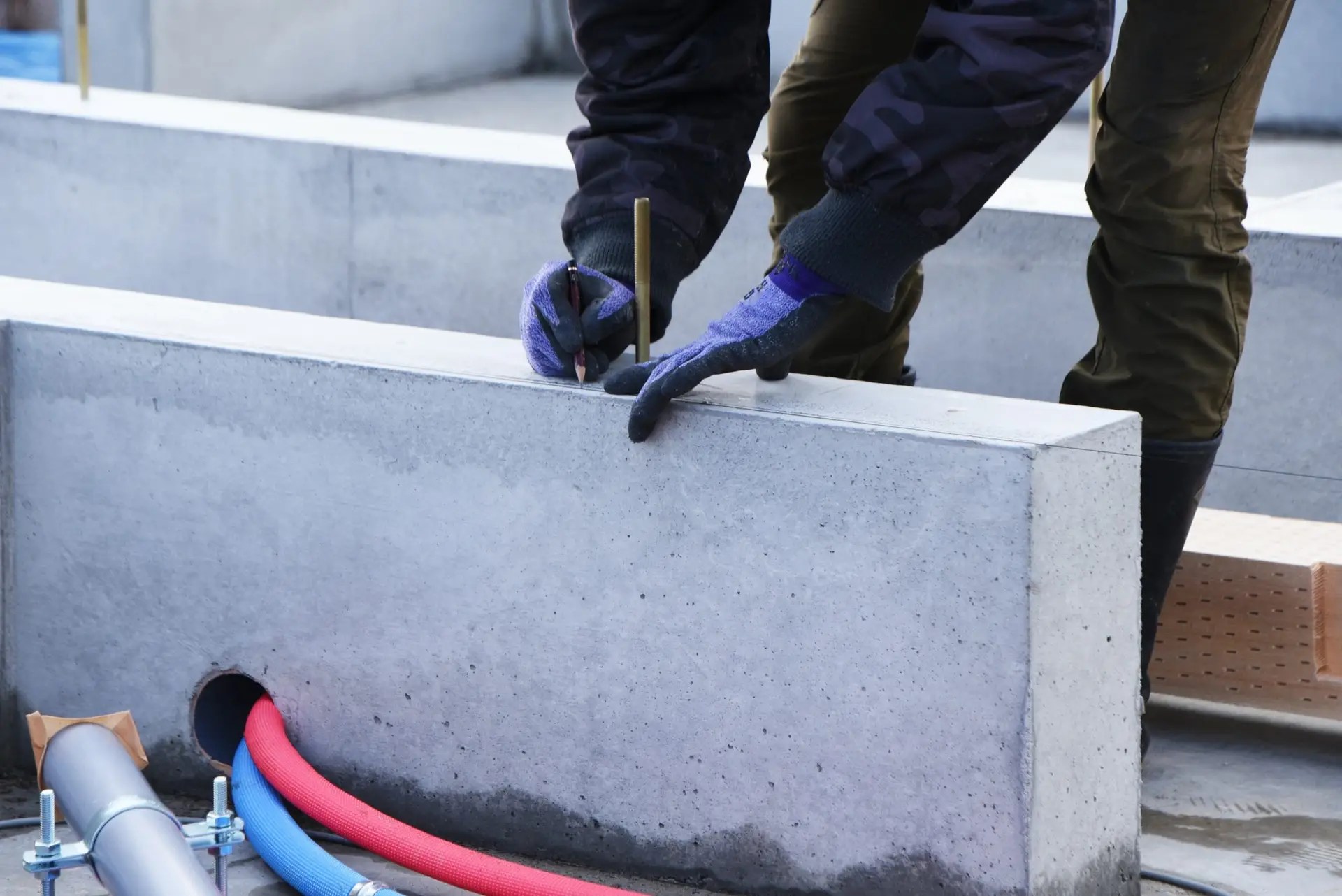 Construction worker installing a new concrete foundation for a house, ensuring stability and durability.