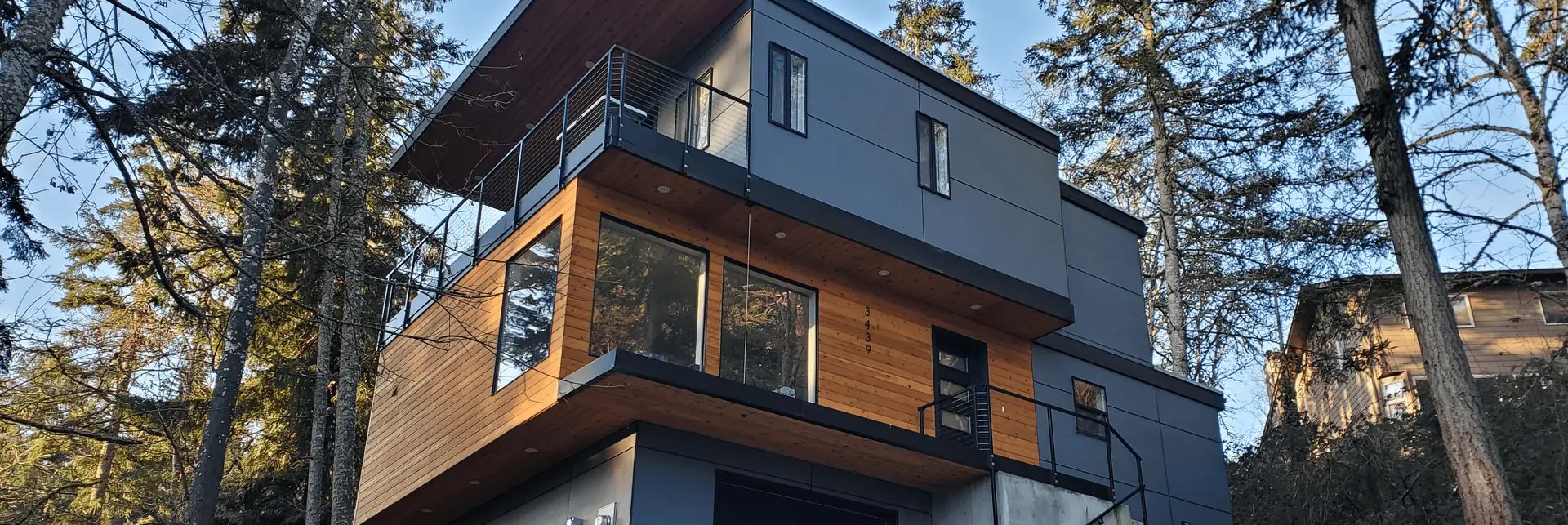 Stunning custom home on Timberline Drive after renovation, featuring modern architecture, large windows, and elegant landscaping.