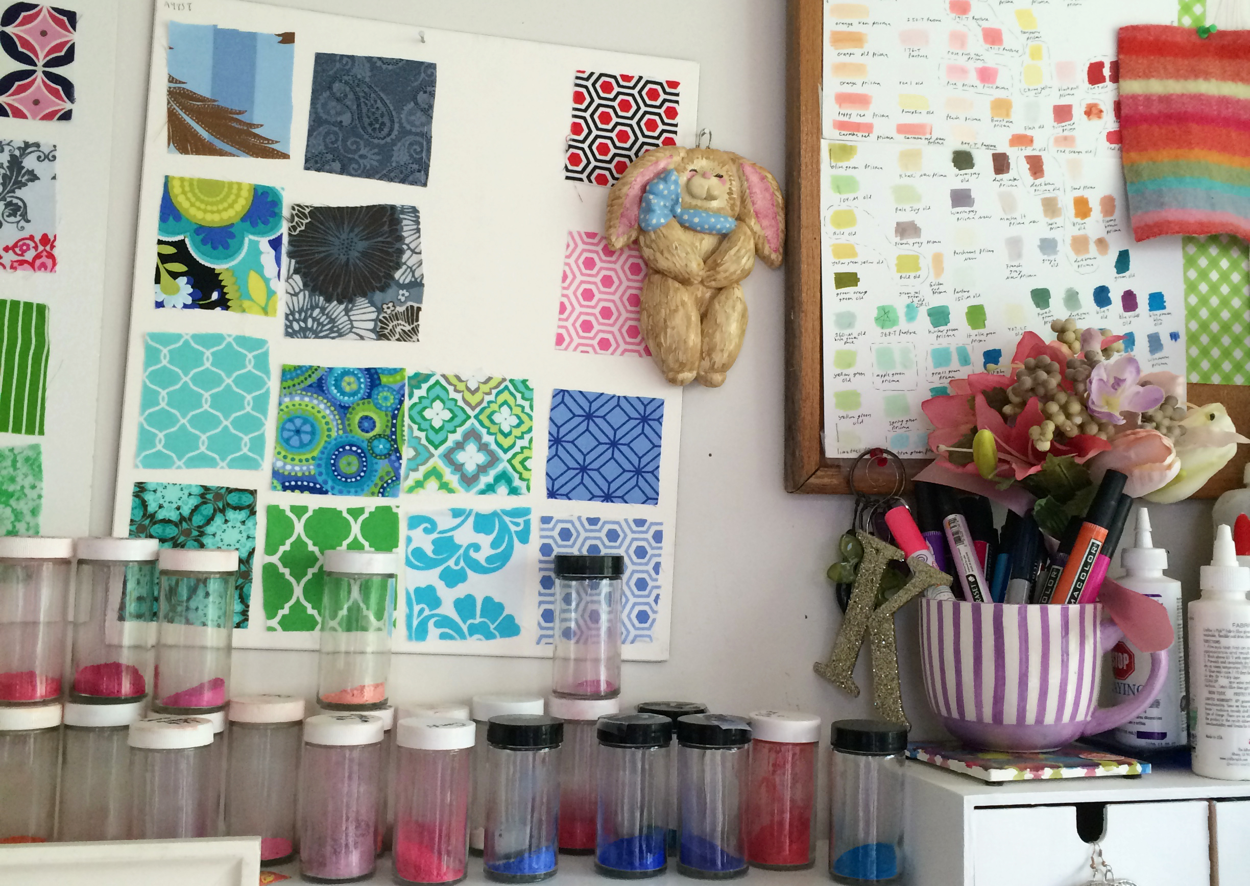 Fabric samples and crushed pastels in jars