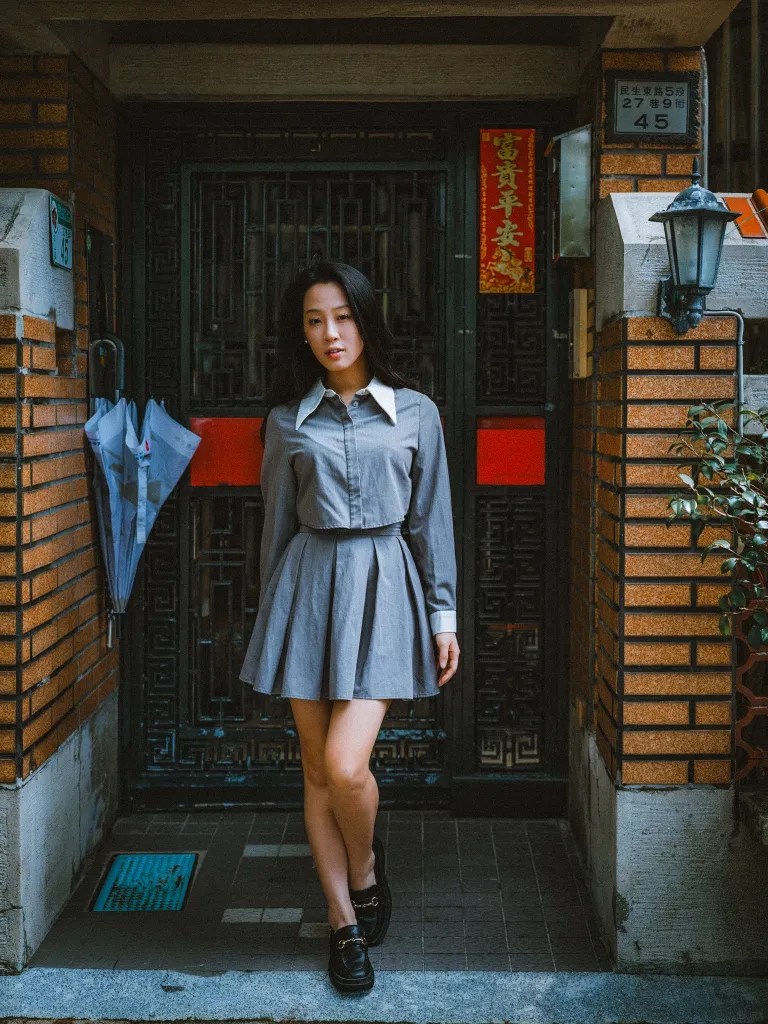 Selina stands before a dark ornate Taipei doorway marked with red decorations.