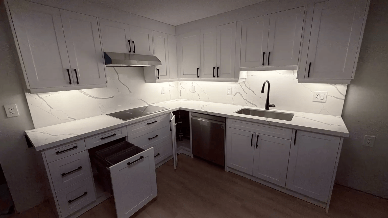 Basement kitchen storage features including pull-out waste bin and corner cabinet