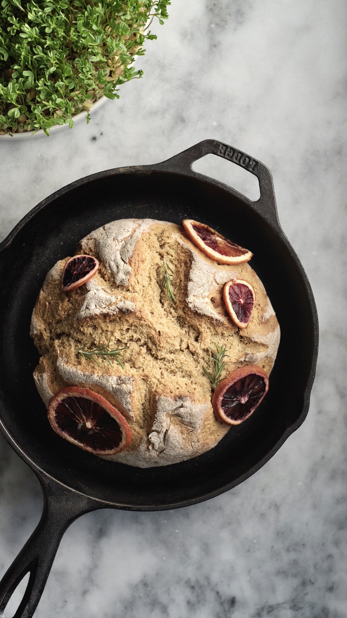 Photograph of orange-rosemary soda bread made using whole grains in a cast-iron skillet