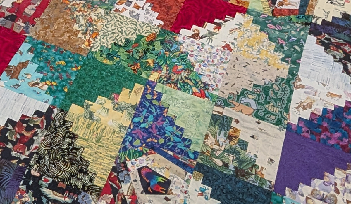 Log cabin quilt blocks made from heavily patterned fabrics.