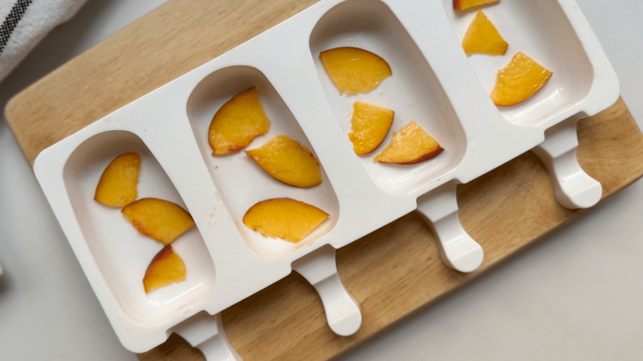 adding peach slice into popcicle mold