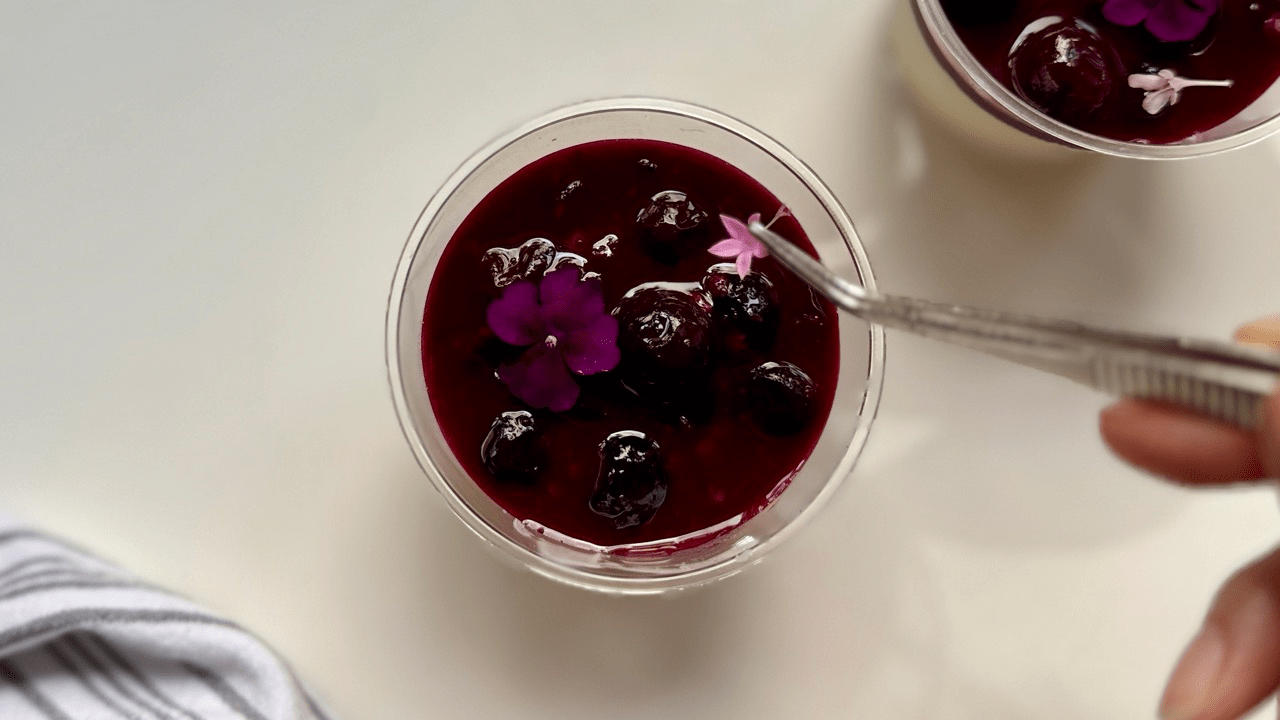 adding edible flower top of the blueberry amakoji panna cotta
