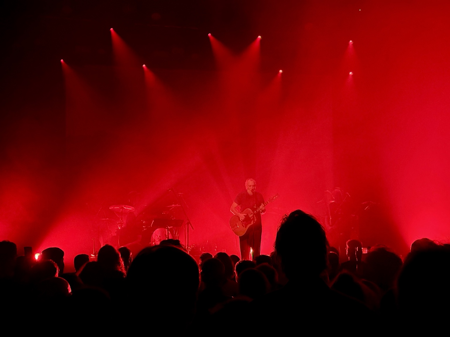 Fink in red stage lighting and mist.