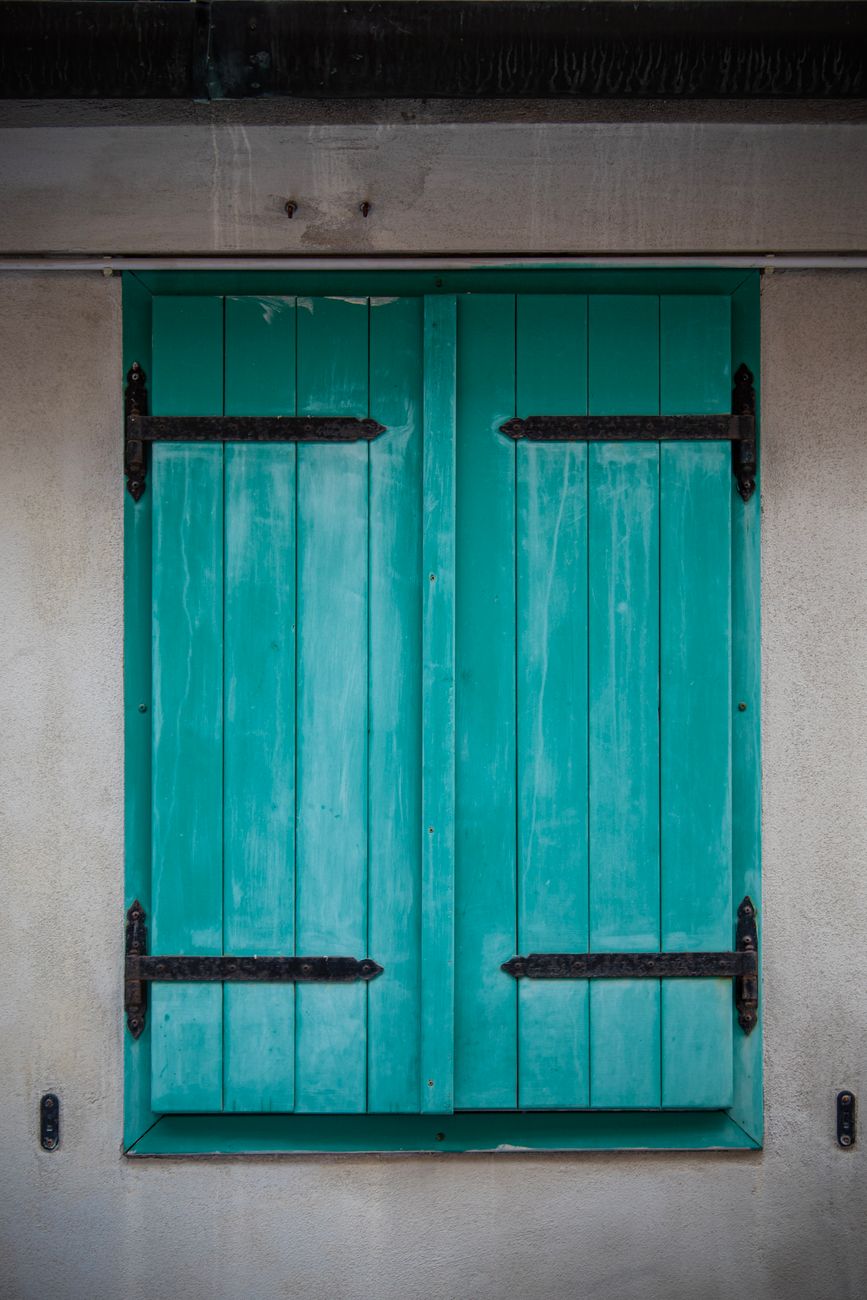 rustic turquoise wooden shutter in italian alley
