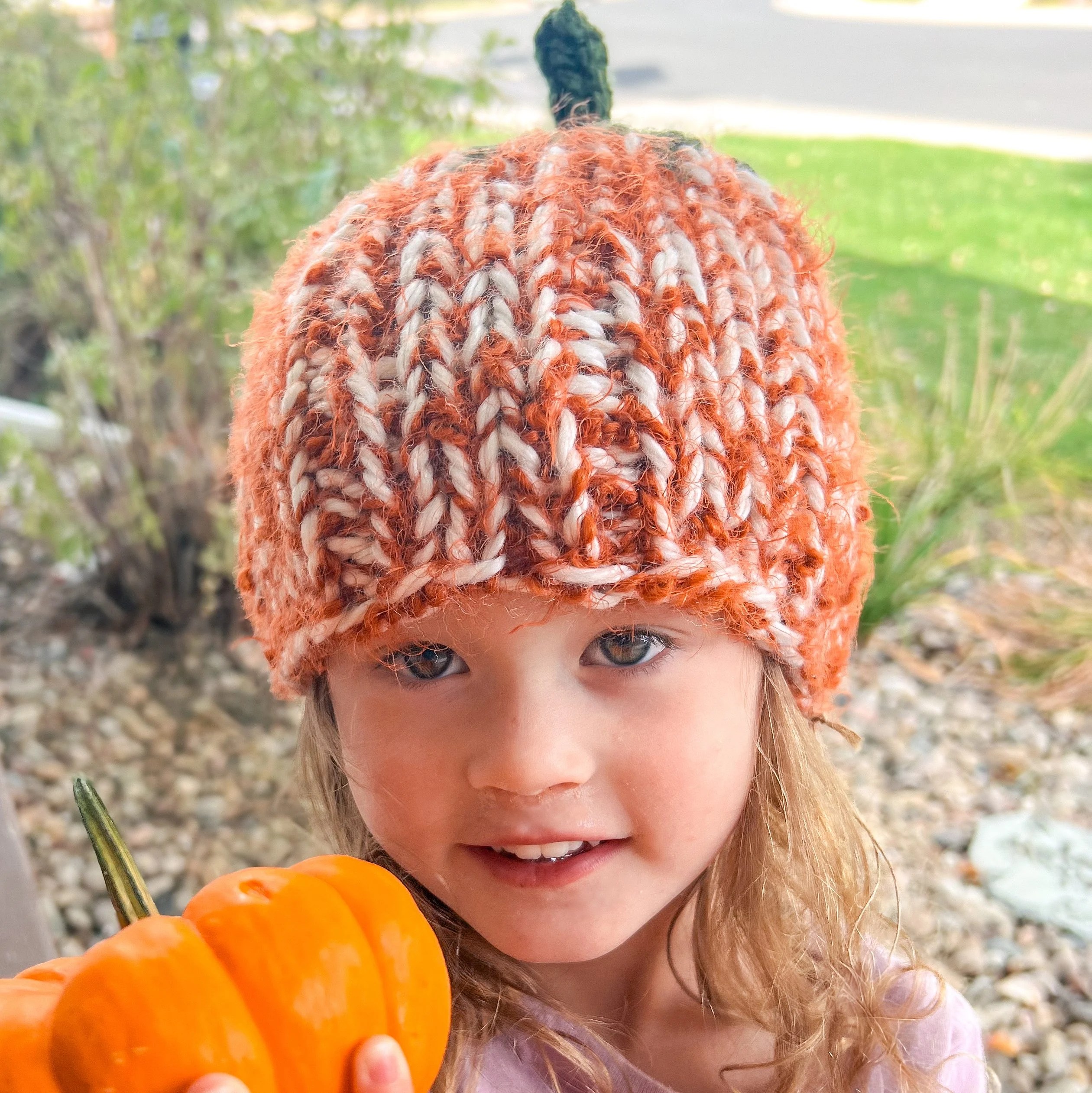 girl wearing a handmade knit hat pumpkin shape