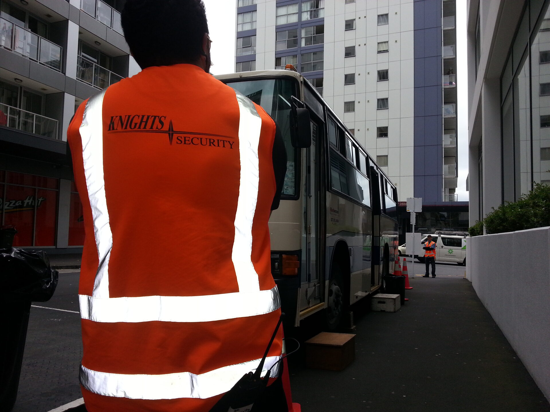 Knights Security branded hi-vis vest worn on a closed city street