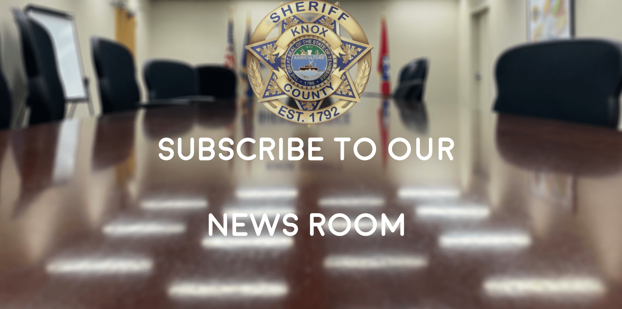 Conference table and chairs with badge and "Subscribe to our newsroom"