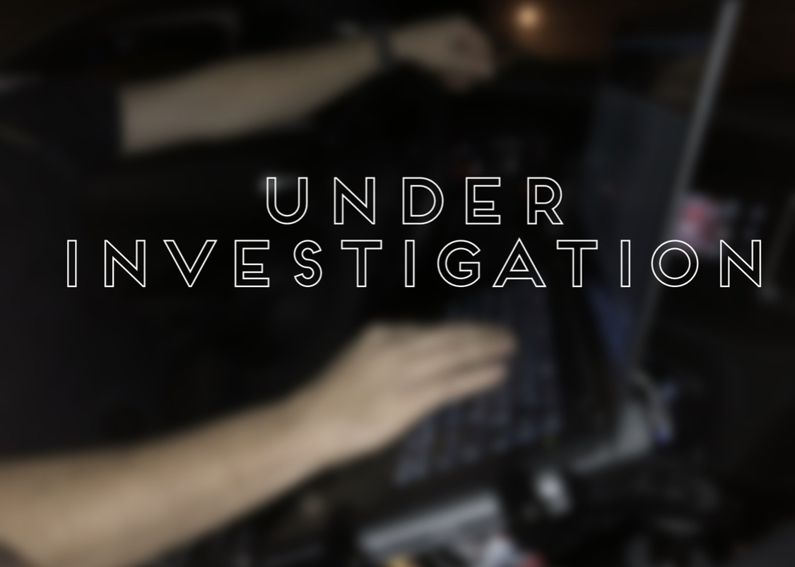 Hands operating computer with "Under Investigation"