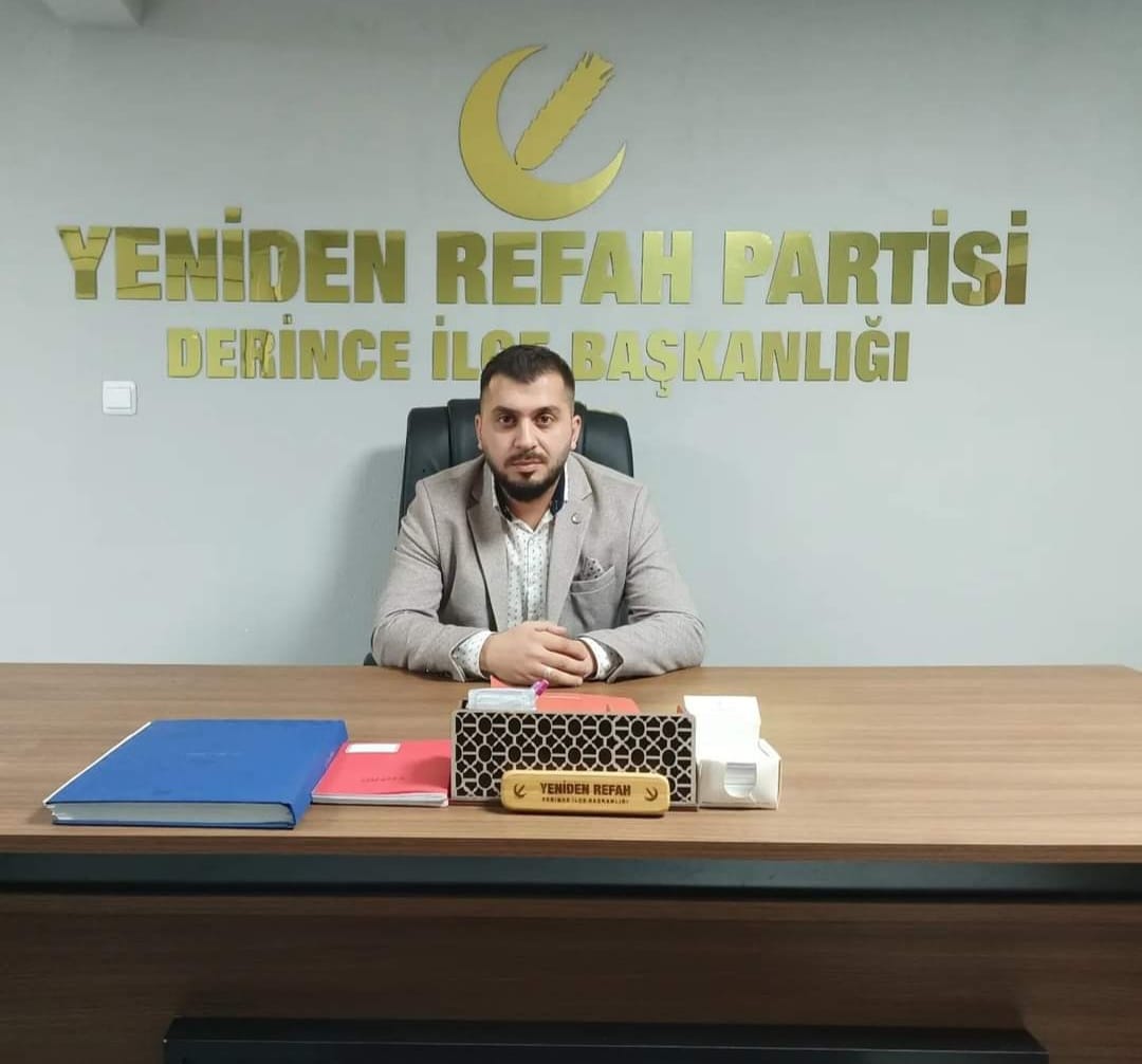 Yeniden Refah Partisi Derince İlçe eski Başkanı Samet Özcan, ofisinde otururken, arkasında parti logosu ve isim panosu ile birlikte görünmektedir.