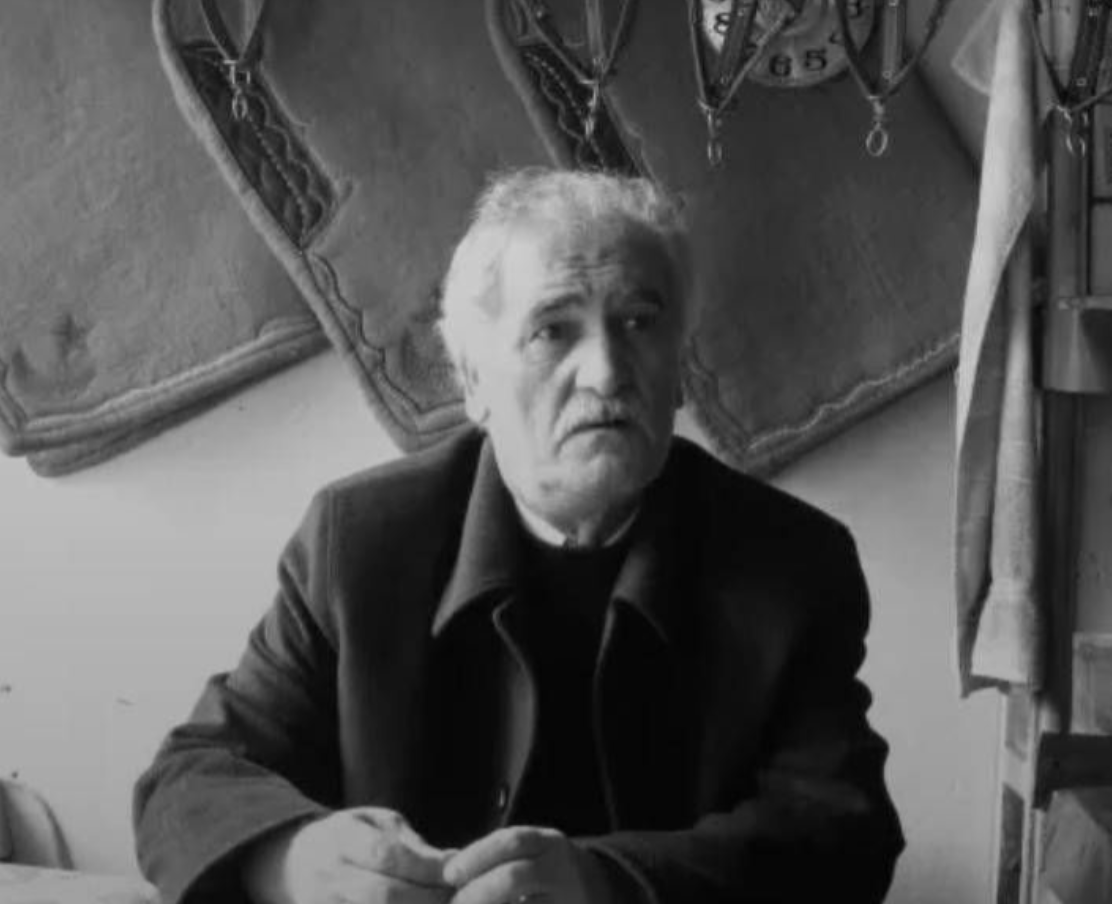 Kocaeli'de vefat eden bir adam, iç mekanında oturuyor. Arkada geleneksel desenlere sahip yastıklar görülüyor.