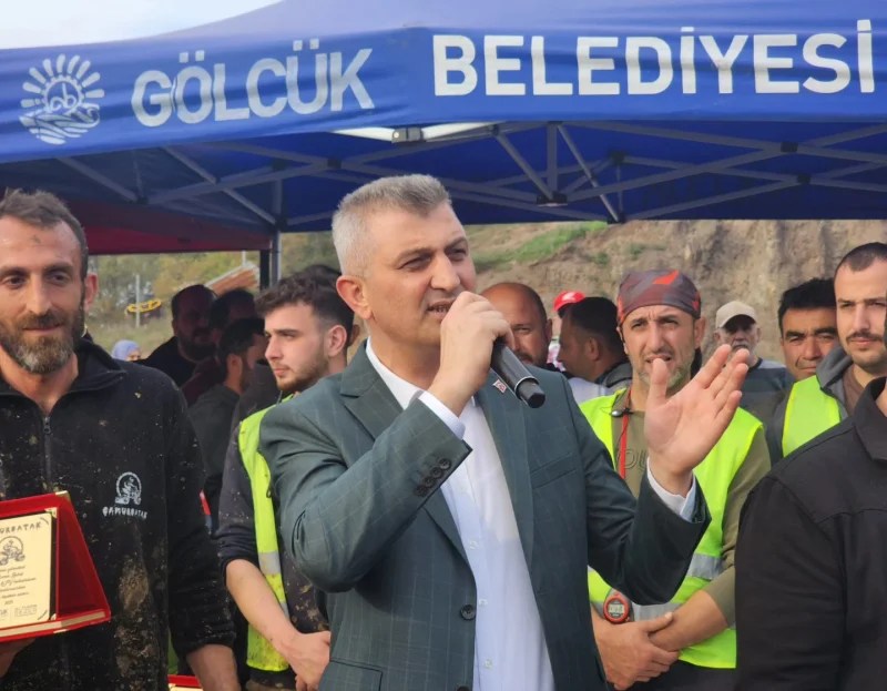 Gölcük Belediye Başkanı Ali Yıldırım Sezer, ATV Yarışları ödül töreninde konuşma yaparken, yanında bir yarışmacı ve kalabalık bir izleyici kitlesi yer alıyor.