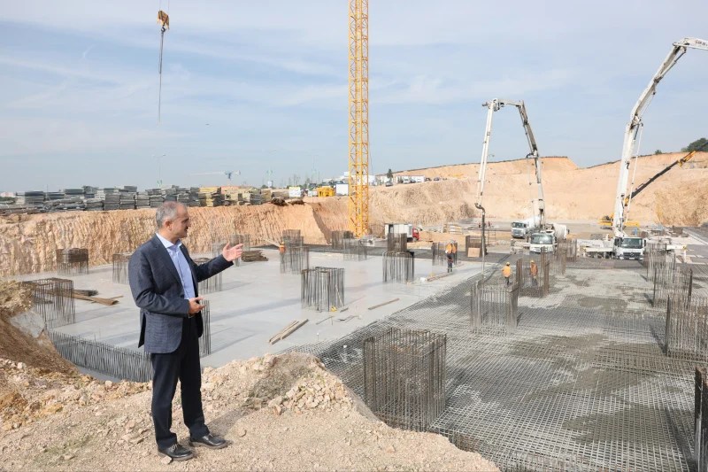 Çayırova Devlet Hastanesi inşaatında temel beton dökümü yapılıyor. İnşaat alanında, temel demirleri ve beton serimi süreçleri görüntüleniyor.