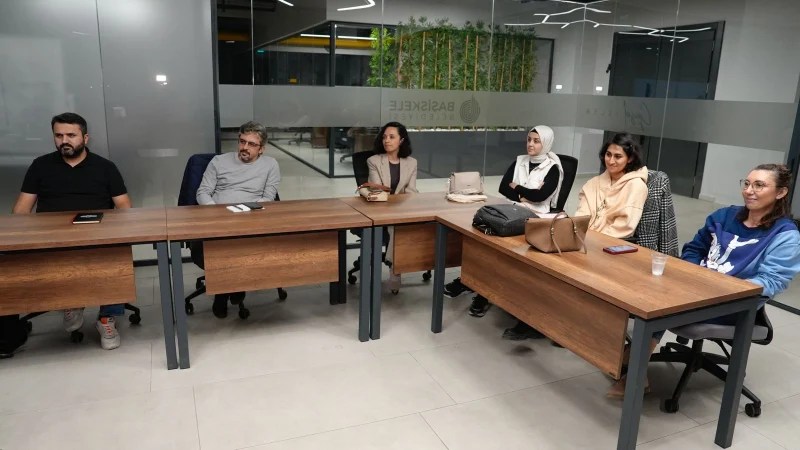Başiskele Türkiye Yüzyılı Gençlik Merkezi'nde bir grup insan, eğitim ve etkinlikler için düzenlenen bir toplantıda oturuyor.