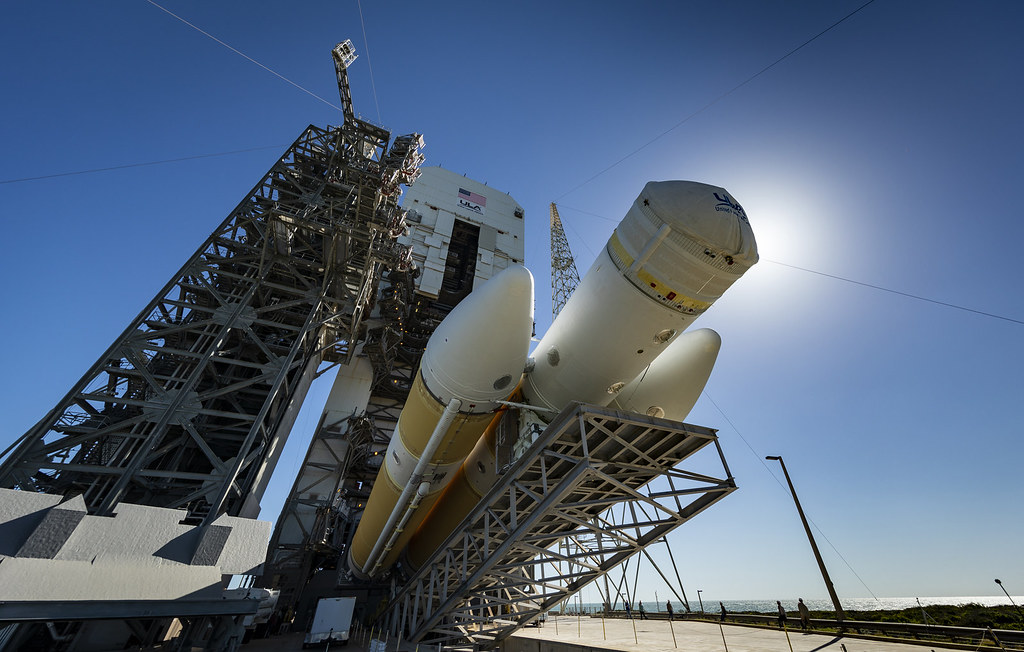 A large rocket standing vertical on its launch pad under a clear blue sky