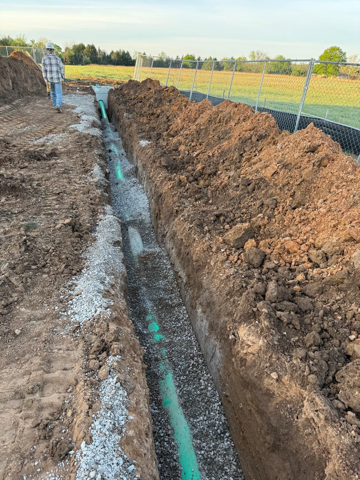 Sanitary sewer pipe bedded in gravel in an open utility trench