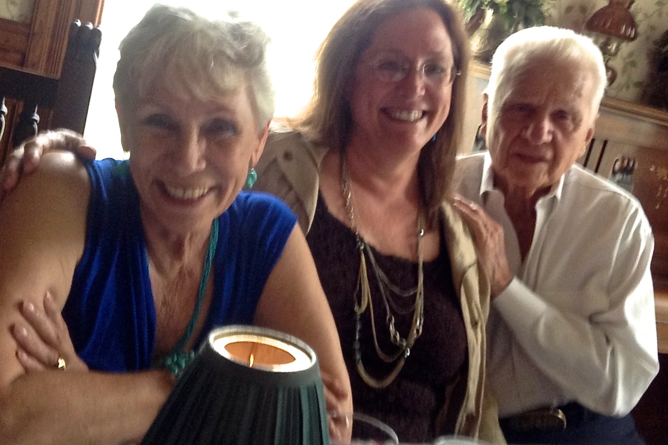 Author K.P. Davis with her mother and father who inspired her chapbook, A Thin Line. Three people sit smiling for a picture.