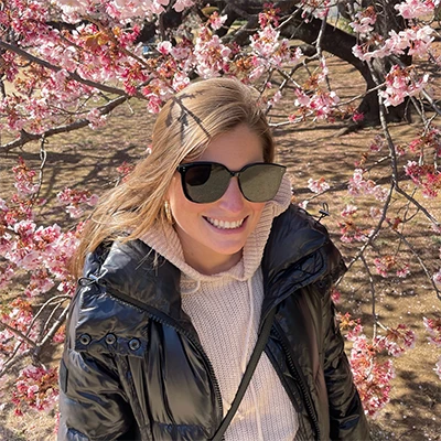Kristin smiling among cherry blossoms