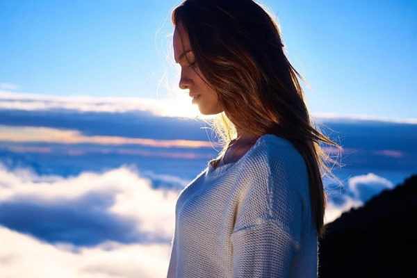Pensive woman with clouds behind her