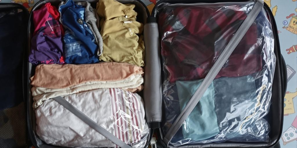 Packed suitcase with vacuum bags and colourful clothes.
