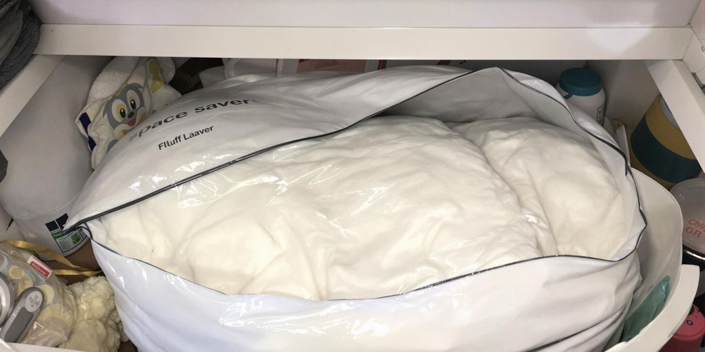 Vacuum-sealed space saver bag with bedding in storage.