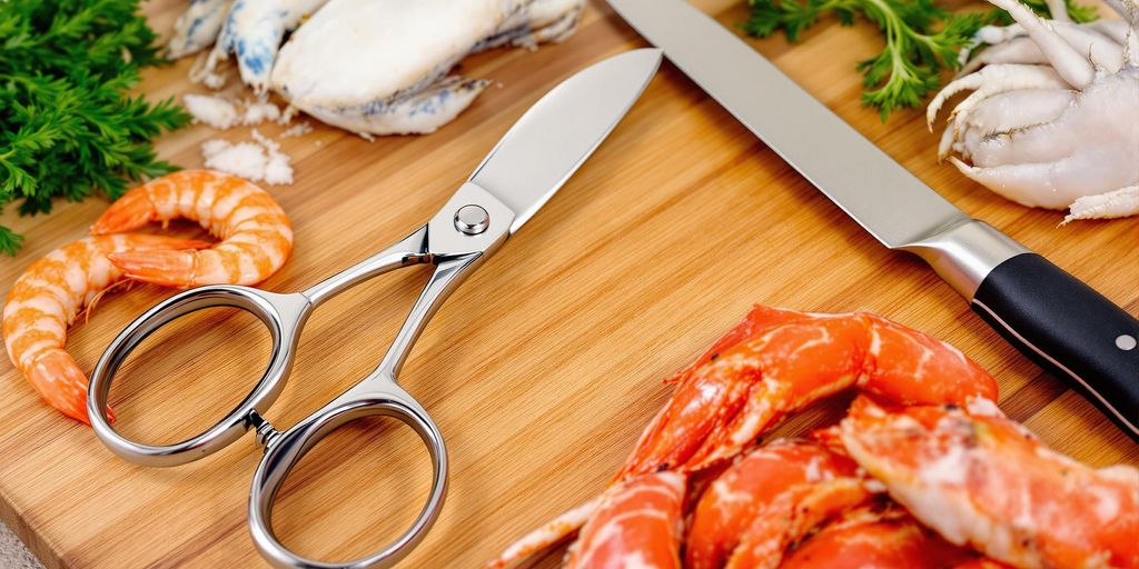 Seafood scissors and knife on a cutting board.
