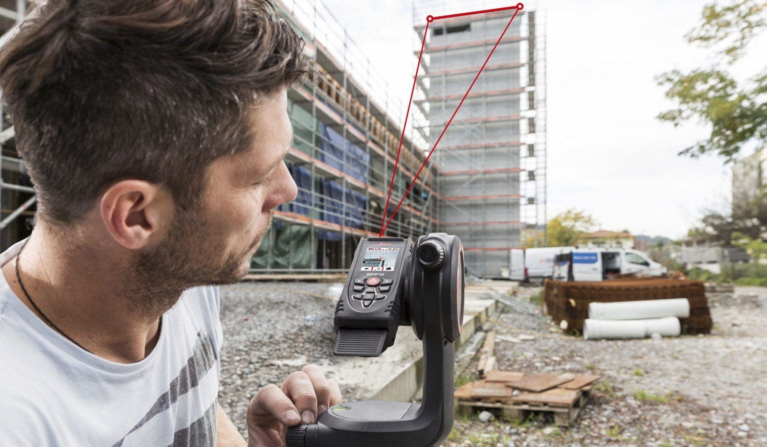 Man using measuring device at construction site.