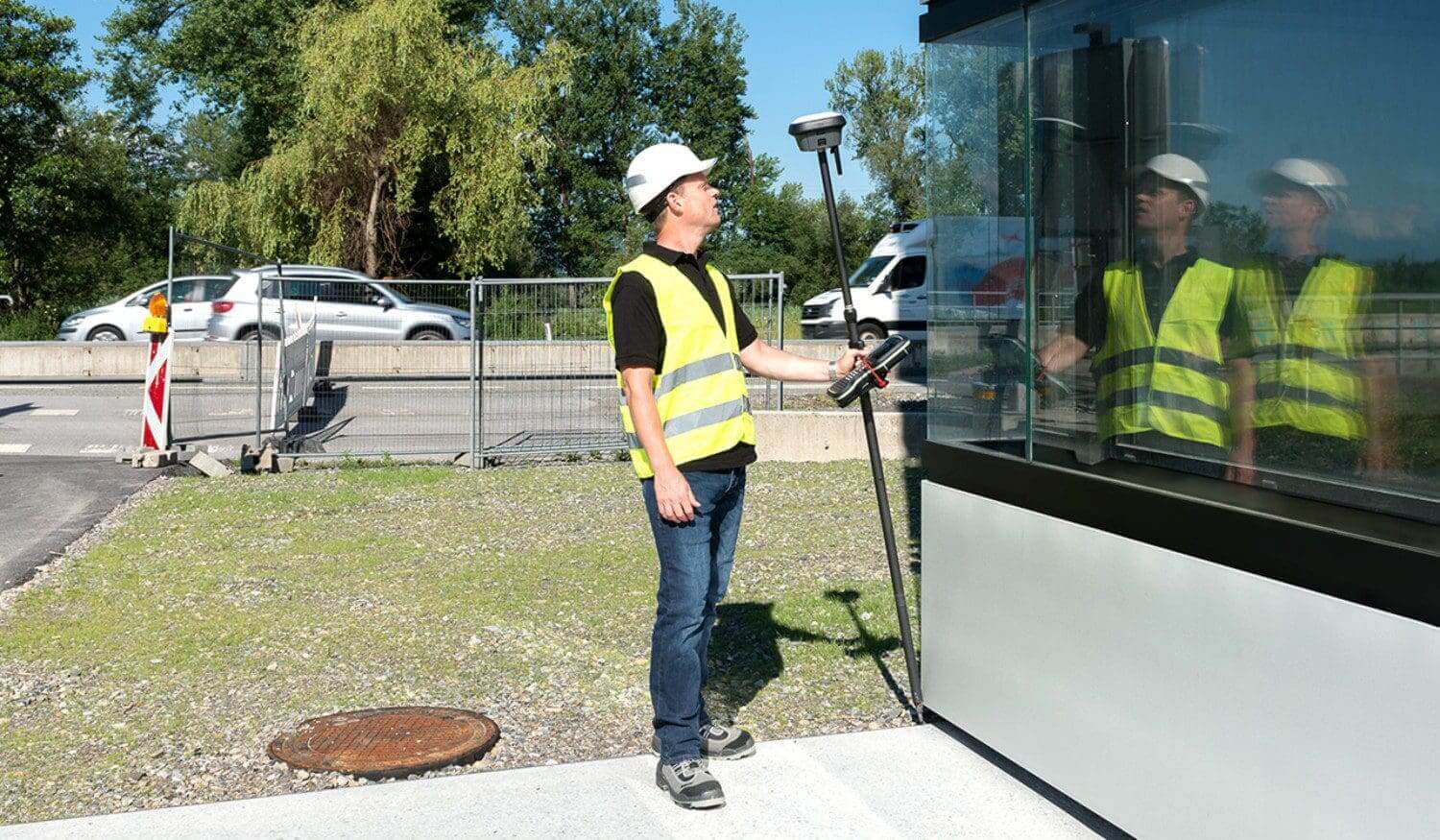 Construction worker using surveying equipment outdoors.