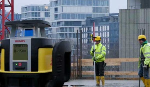 Construction site with workers and laser level.