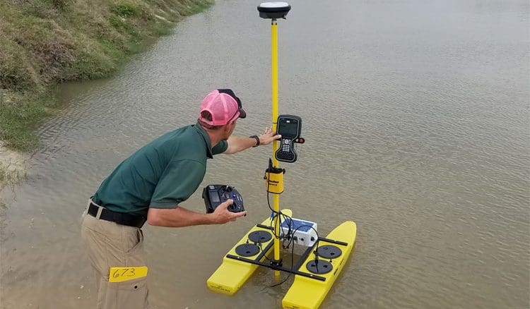 Man operating remote-controlled water surveying device.