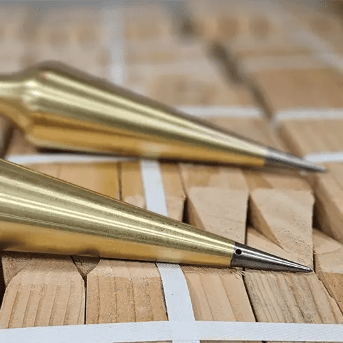 Brass plumb bobs on wooden surface.