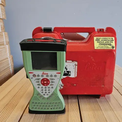 Surveying equipment and red case on table.