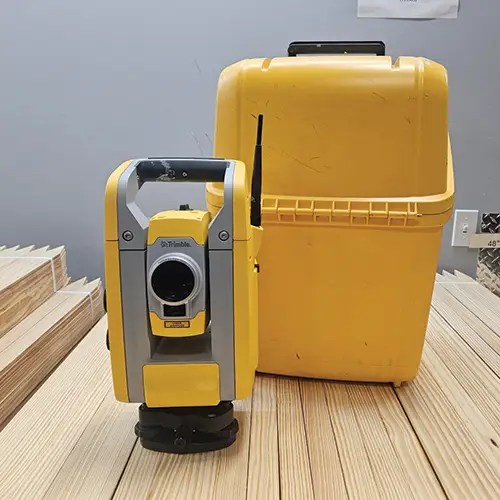 Yellow surveying instrument with matching case.