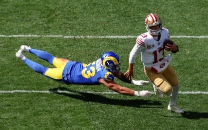 El quarterback número 13 de los San Francisco 49ers, Brock Purdy (derecha), corre con el balón durante el partido de la NFL entre Los Angeles Rams y los San Francisco 49ers en el Melbourne Cricket Ground (MCG) en Melbourne el 10 de septiembre de 2026. Foto Afp