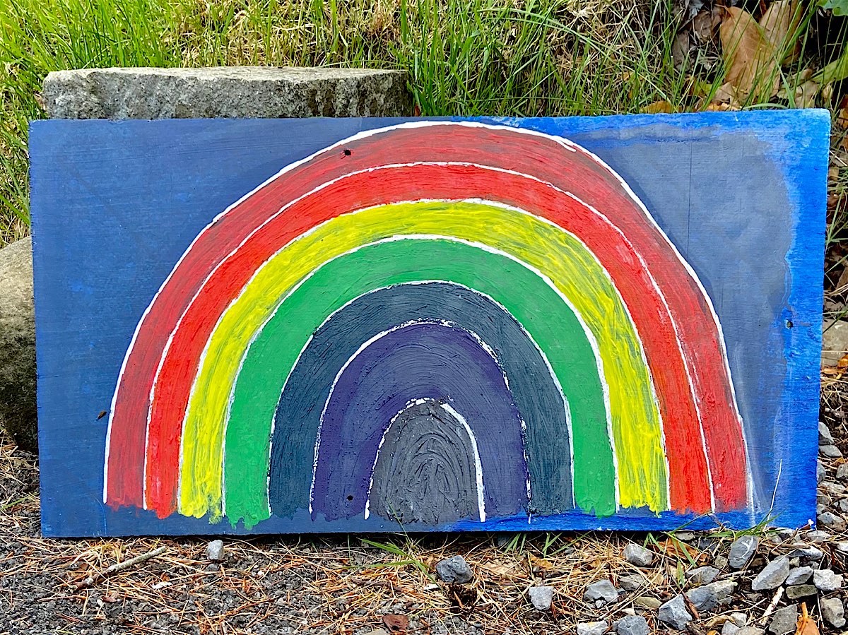A large rainbow painted onto slate with a midnight blue background
