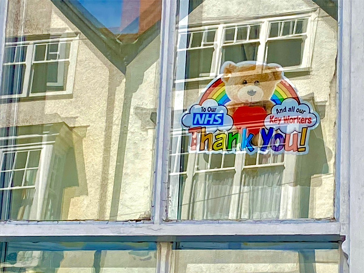 This is a printed image with a big teddy holding red heart sitting in front of a rainbow, there are clouds at either end, one says To our NHS and the other says And all our Key workers and at the bottom its says Thank You. Unfortunately this picture is not a good one