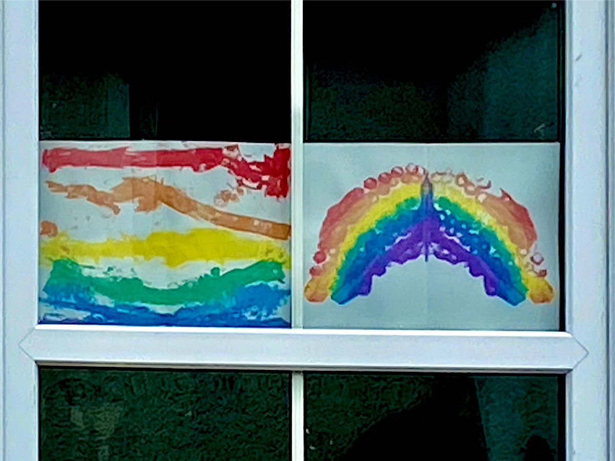 two rainbows side by side in a window, they look like they are made by very young children