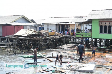 Sejumlah warga terlihat merapihkan puing-puing rumah yang hancur diterjang ombak, di pesisir pantai Kelurahan Kangkung, Kecamatan Bumi Waras, Bandarlampung, Kamis (29/7/2021). FOTO: Sulaiman