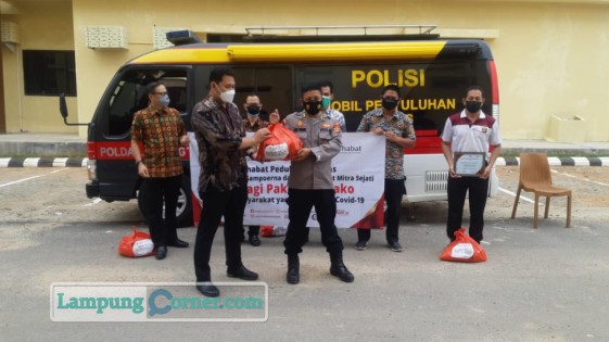 Area Manager KSP Sahabat Mitra Sejati Area Lampung Aris Susanto meberikan paket sembako secara simbolis kepada perwakilan Polda Lampung, Jumat (20/8/2021). FOTO: Sulaiman